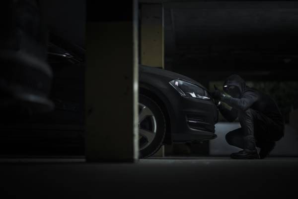 mężczyzna otwiera maskę samochodu w celu wykonania usługi - oklejanie samochodów cena Lubin